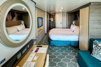The stateroom looking forward from the balcony door, twin beds made up as a double.